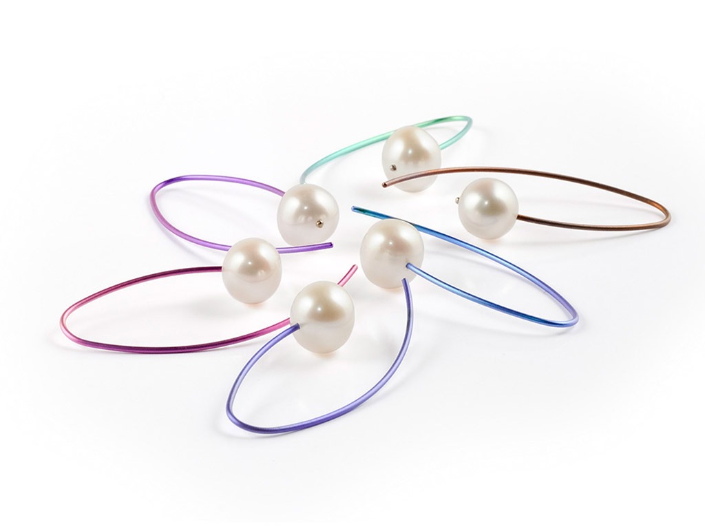 A group of three white scissors on a wooden surface.
